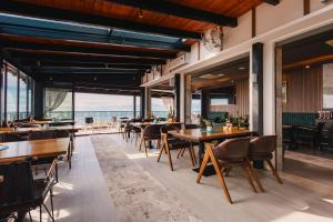 a restaurant with tables and chairs and a view of the ocean at Padam Hotel & SPA in Ulcinj