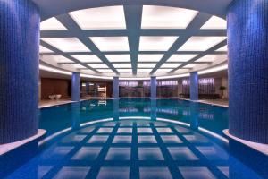 a large swimming pool with blue tile floors and a ceiling at Four Points by Sheraton Taicang in Taicang