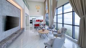 a living room with a television and a table and chairs at Grand Ion Delemen Plus in Genting Highlands