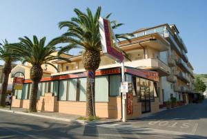 a large building with palm trees and palm trees at Hotel President in Vasto