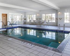 a swimming pool with tables and chairs in a building at Comfort Inn Owatonna near Medical Center in Owatonna