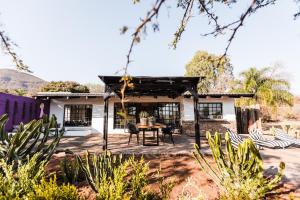 a patio with a table and chairs in front of a house at Cypiro Leopard Lodge in Kransberg