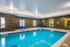a large swimming pool in a building with blue chairs at Comfort Suites Fishkill near Interstate 84 in Fishkill