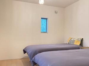 a bedroom with two beds and a window at The ITO 伊藤 in Abiko