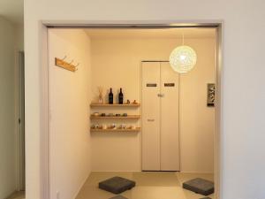 a hallway with a door and a shelf with bottles at The ITO 伊藤 in Abiko +86 photos