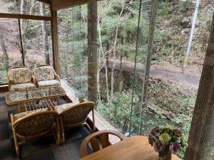 a screened in porch with two chairs and a table at ペンション愛宕道 in Kyoto