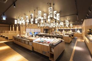 a restaurant with a large chandelier above the counter at Ooedo Onsen Monogatari Premium Seiunkaku in Awara