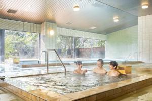three people in a bathtub in a swimming pool at Ooedo Onsen Monogatari Premium Seiunkaku in Awara +68 photos