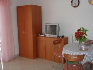 a room with a table and a tv on a cabinet at Apartments Eden in Jadranovo