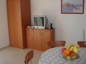 a room with a table with a bowl of fruit on it at Apartments Eden in Jadranovo +16 photos