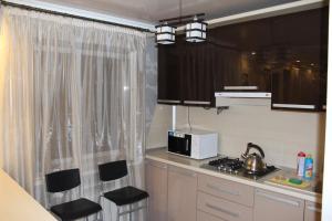 ナリチクにあるLux Apartment on Leninaのキッチン(黒いキャビネット、電子レンジ、コンロ付)
