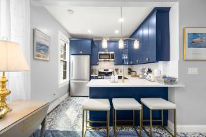 a kitchen with blue cabinets and white appliances at Bright 2BR Retreat Walk to PATH NYC Access in Jersey City