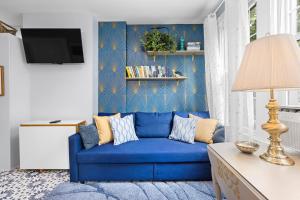 a blue couch in a living room with a blue wall at Bright 2BR Retreat Walk to PATH NYC Access in Jersey City
