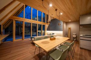 a kitchen and dining room with a wooden table and chairs at ERUSA Rusutsu in Rusutsu