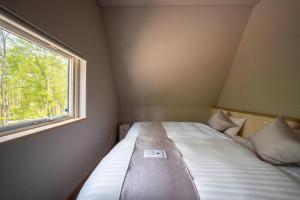 a bed in a small room with a window at ERUSA Rusutsu in Rusutsu +137 photos