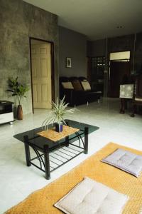 a living room with a table and a couch at บ้านมนต์รักเชียงดาว in Chiang Dao