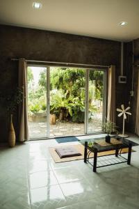 a living room with a table and a large window at บ้านมนต์รักเชียงดาว in Chiang Dao
