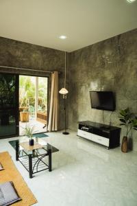 a living room with a flat screen tv on a wall at บ้านมนต์รักเชียงดาว in Chiang Dao
