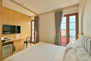 a hotel room with a bed and a television at HANZ Lagoon Sunset Hotel in Phú Quốc