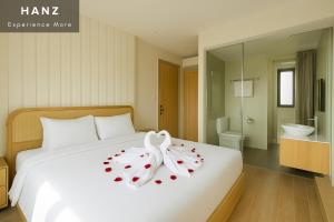 a hotel room with a bed with a flower on it at HANZ Lagoon Sunset Hotel in Phú Quốc