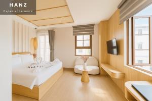 a hotel room with a bed and a tv at HANZ Lagoon Sunset Hotel in Phú Quốc