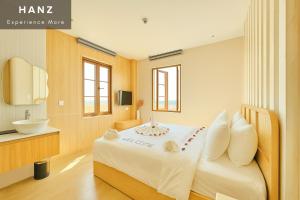 a bedroom with a large white bed and a sink at HANZ Lagoon Sunset Hotel in Phú Quốc +117 photos