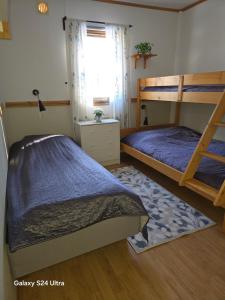 a bedroom with two bunk beds and a window at Haga gård och Stall in Herräng