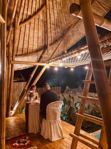 a man sitting at a table in a restaurant at Hidden Bamboo Village in Sidemen
