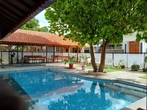 a pool in front of a house with a tree at Sabi Studio in Timuran