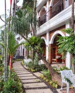 a walkway in front of a building with palm trees at Sabi Studio in Timuran