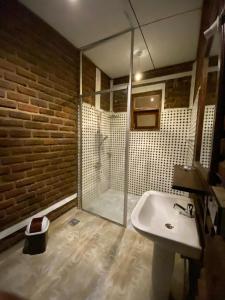 a bathroom with a glass shower and a sink at Diduli Hotel in Ella