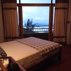 a bedroom with a bed with a view of the ocean at Diduli Hotel in Ella
