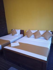 two beds sitting next to each other in a room at Diduli Hotel in Ella