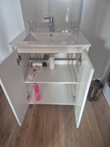 a white bathroom sink sitting on top of a wooden floor at le st fursy 1 in Péronne +20 photos