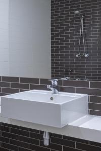 a white sink in a black bathroom with a mirror at Bay View - Ocean Nest in Lorne +14 photos