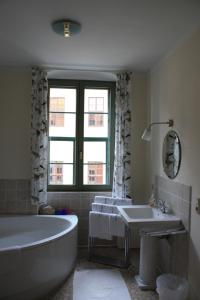 a bathroom with a large tub and a sink at Haus Buchheim - Pension am Schloss in Bautzen