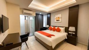 a hotel room with a bed and a desk and a computer at Grand Ion Delemen Plus in Genting Highlands