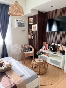 a bedroom with a bed and a desk and a chair at Baan Mai Condo Staycation in Biñan
