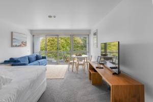 a bedroom with a bed and a table with a blue couch at Bay View - Ocean Nest in Lorne