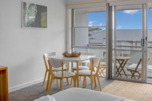 a dining room with a table and chairs and a balcony at Bay View - Ocean Nest in Lorne