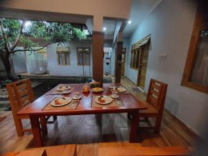 a wooden table with plates of food on it at Hamemayu Homestay in Jejeran