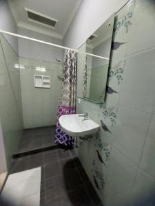 a bathroom with a sink and a shower curtain at Hamemayu Homestay in Jejeran