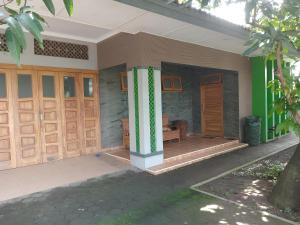 a house with wooden doors and a porch at Hamemayu Homestay in Jejeran
