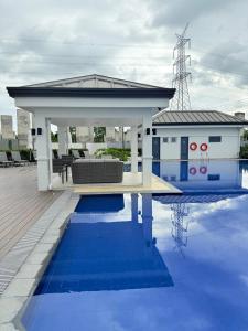 a house with a pavilion next to a pool at Baan Mai Condo Staycation in Biñan