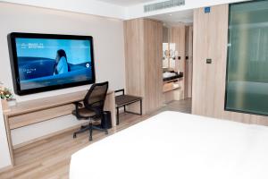 a living room with a television on a wall at Atour Hotel High Speed Railway North Station Zibo Hi tech Zone in Zibo