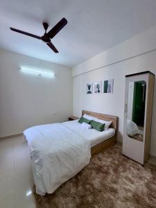 a bedroom with a bed with a ceiling fan at Live Easy in Mātigara +2 photos