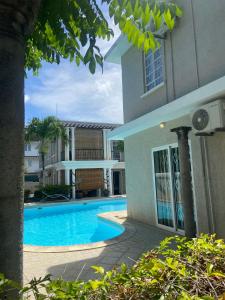 a house with a swimming pool next to a building at Solmera Villa in Grand-Baie