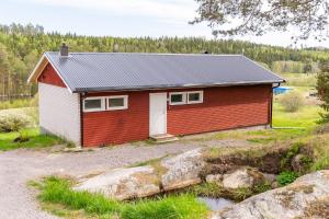 a red and white house in a field at Lagom huset in Årjäng