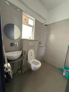 a bathroom with a white toilet and a sink at Live Easy in Mātigara
