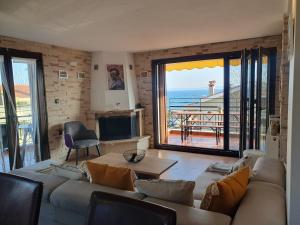 a living room with a couch and a view of the ocean at Teo`s Seaview Specious Apartment, Nikiti near Harbor in Nikiti